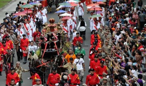   Gubernur DKI Jakarta Joko Widodo dan Wakil Gubernur Basuki Tjahaja Purnama menyapa warga diatas kereta kencana saat mengikuti kirab di Jalan Medan merdeka Barat, Jakarta, Ahad (8/12).  (Republika/Yasin Habibi)