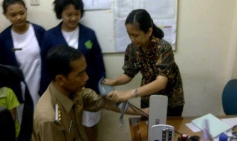 Gubernur DKI Jakarta, Joko Widodo (Jokowi) ikut periksa tekanan darah saat sidak di Puskesmas Kramat Sentiong, Jakpus.