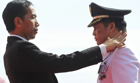   Gubernur DKI Jakarta Joko Widodo (kiri) menyematkan tanda pangkat dan jabatan kepada Bupati Kepulauan Seribu Asep Syarifudin (kanan) saat acara pengambilan sumpah dan pelantikan di Pantai Pasir Perawan, Pulau Pari, Kepulauan Seribu, Rabu (5/6).   (Antara