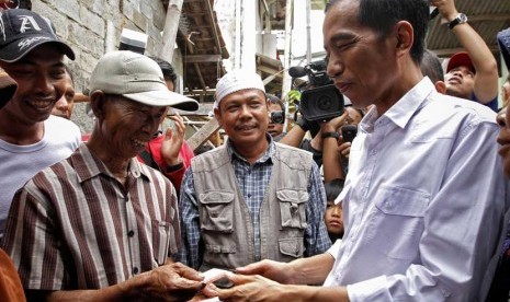  Gubernur DKI Jakarta, Joko Widodo membagikan Kartu Jakarta Sehat kepada penduduk kelurahan Marunda di Jakarta Utara, Senin (12/11). (Adhi Wicaksono)