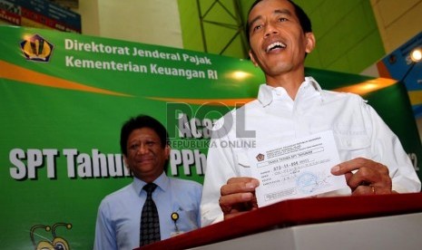  Gubernur DKI Jakarta Joko Widodo menunjukan SPT Pajak Penghasilan (PPh) pribadi tahun 2012 di Pasar Tanah Abang, Jakarta Pusat, Senin (18/03).  (Republika/Prayogi)