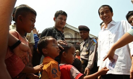 Gubernur DKI Jakarta Joko Widodo saat menyaksikan   pembagian sembako di  Muara Angke, Penjaringan, Jakarta Utara, Ahad (4/8). (Republika/Adhi Wicaksono)