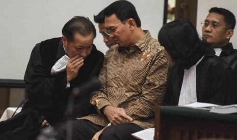 Gubernur DKI Jakarta nonaktif Basuki Tjahaja Purnama alias Ahok (tengah) berbincang dengan penasehat hukumnya saat menjalani sidang lanjutan kasus dugaan penistaan agama di PN Jakarta Utara, Auditorium Kementerian Pertanian, Jakarta, Rabu (29/3). 