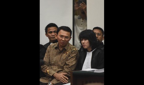 Gubernur DKI Jakarta nonaktif Basuki Tjahaja Purnama alias Ahok (kiri) berbincang dengan penasehat hukumnya saat menjalani sidang lanjutan kasus dugaan penistaan agama di PN Jakarta Utara, Auditorium Kementerian Pertanian, Jakarta, Rabu (29/3). 