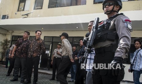 Gubernur DKI Jakarta nonaktif Basuki Tjahaja Purnama (kedua kiri) berbincang dengan petugas Kepolisian seusai menjalani sidang lanjutan kasus dugaan penistaan agama di PN Jakarta Utara, Jakarta, Selasa (20/12).