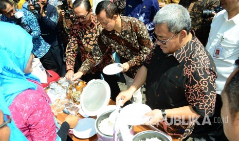 Gubernur Jabar Ahmad Heryawan bersama para pejabat lain mencoba nasi dari beras raskin atau beras sejahtera (Rastra) pada acara 