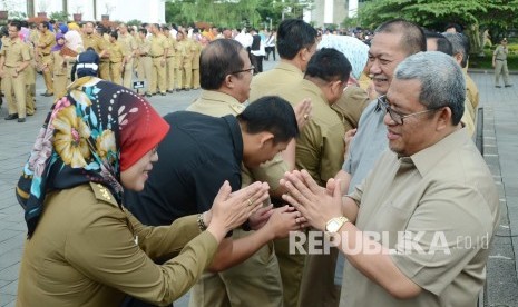 Gubernur Jabar Ahmad Heryawan, dan Wakil Gubernur Jabar Deddy Mizwar bersalaman dengan para Pegawai Negeri Sipil (PNS) pada upacara pagi hari pertama masuk kerja usai libur Lebaran, di Halaman Gedung Sate, Kota Bandung, Senin (11/7). (Republika/Edi Yusuf)