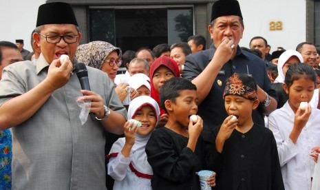 Gubernur Jabar Ahmad Heryawan (kiri) dan Wagub Dedy Mizwar (kanan) bersama para pelajar mengonsumsi telur dan susu dalam perayaan Hari Pangan se-Dunia di pelataran Gedung Sate Bandung, Jawa Barat, Rabu (7/10). 