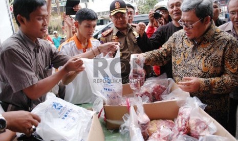 Gubernur Jabar Ahmad Heryawan membeli daging sapi saat meninjau operasi pasar daging sapi, di Pasar Kosambi, Kota Bandung, Rabu (12/8).