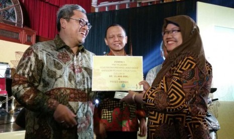 Gubernur Jabar Ahmad Heryawan menyerahkan Anugerah PNS Teladan kepada Kepala Seksi Pemerintah dan Pemerintah Daerah, Diskominfo Provinsi Jabar Dra Hj Lovita Adriana Rosa MSi, belum lama ini.