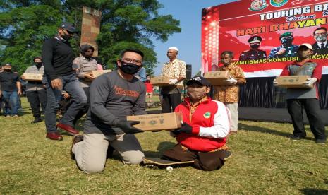 Gubernur Jabar Ridwan Kamil, bersama Fomkompimda Provinsi Jabar menyaluran bantuan sembako kepada warga di Alun-Alun Manonjaya, Kabupaten Tasikmalaya, Ahad (5/7). Penyaludna bantuan itu dilakukan dalam rangka Touring Bakti Sosial Hari Bhayangkara ke-74.