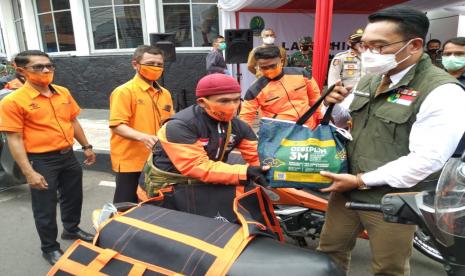 Gubernur Jabar Ridwan Kamil melepas komunitas ojol dan petugas pos untuk menyalurkan bansos Pemprov Jabar di Kantor Pos Kabupaten Garut, Jalan Ahmad Yani, Selasa (27/10). Sekira 100 ribu paket bansos dari Pemprov Jabar akan disalurkan kepada warga Kabupaten Garut.