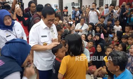 Gubernur Jakarta Pramono Anung menghibur anak-anak yang mengungsi di GOR Otista, Jakarta Timur, akibat terdampak banjir, Rabu (5/3/2025). 