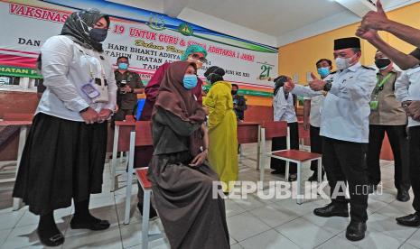 Gubernur Jambi Al Haris (kanan) menyemangati seorang pelajar yang akan menerima suntikan vaksin saat meninjau vaksinasi COVID-19 di SMA Adhyaksa 1 Jambi, Jambi, Rabu (14/7/2021). Vaksinasi massal yang menargetkan pelajar dan guru di lingkungan sekolah di bawah naungan Ikatan Adhyaksa Dharmakarini wilayah Jambi tersebut bagian dari sinergitas dan upaya lintas instansi untuk menekan jumlah kasus COVID-19 yang kembali naik dalam beberapa hari terakhir di daerah itu. 