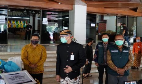 Gubernur Jateng Ganjar Pranowo berpakaian adat Jawa didampingi Kepala Hubungan Daerah PT HM Sampoerna Kukuh Dwi Kristanto dan Direktur Yayasan Rumah Kita Surabaya Andrinus Uran mengamati bantuan Covid-19 di halaman kantor Gubernur Jalan Pahlawan Semarang, Kamis (18/6)