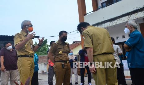 Gubernur Jateng Ganjar Pranowo (kedua kiri) berbincang dengan Bupati Kudus Hartopo (tengah) di tempat karantina saat meninjau penanganan kasus Covid-19 di Kudus.