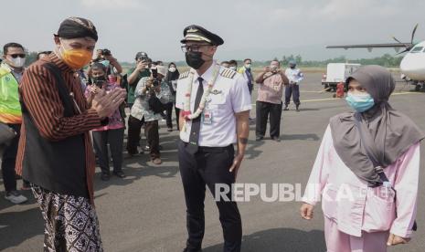 Gubernur Jateng Ganjar Pranowo (kiri), menyambut pilot maskapai penerbangan Citilink yang mendarat dari Surabaya di Bandara Jenderal Besar Soedirman (JBS), Purbalingga, Jawa Tengah, Kamis (3/6/2021). Sebanyak 24 penumpang mendarat dari Surabaya dan 37 penumpang berangkat menuju Jakarta pada penerbangan komersial perdana di Bandara JBS, menandai dimulainya operasional bandara secara komersial. 