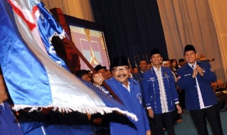 Gubernur Jatim yang juga Ketua DPD PD Jatim, Soekarwo (kiri) membawa bendera Partai Demokrat disaksikan oleh Ketua Umum DPP Partai Demokrat, Anas Urbaningrum (kanan).