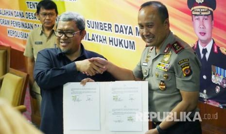 Gubernur Jabar Ahmad Heryawan dan Kapolda Jabar Irjen Pol Agung Budi Maryoto memegang lembar kesepakan kerjasama Penanganan Permasalahan Dana Desa dan Peningkatan Sumber Daya Manusia Melalui Program Pembinaan dan Pelatihan di Wilayah Hukum Kepolisian Daerah Jabar, di Gedung Sate, Kota Bandung, Senin (30/10).