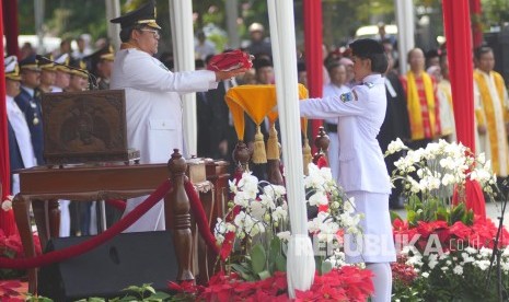 Gubernur Jawa Barat Ahmad Heryawan menyerahkan bendera pusaka kepada Paskibraka pada upacara peringatan Hari Ulang Tahun ke-72 Republik Indonesia tingkat Provinsi Jabar, di Lapangan Gasibu, Kota Bandung, Kamis (17/8).