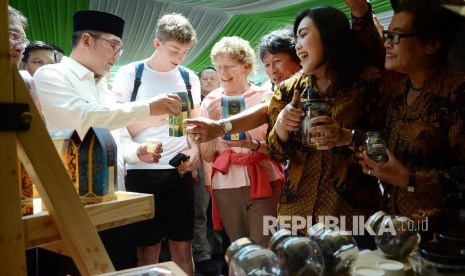 Gubernur Jawa Barat Ridwan Kamil berbincang dengan pengunjung saat meninjau acara West Java Bandung Tea Festival, di halaman parkir Gedung Sate, Kota Bandung, Jumat (2/8).