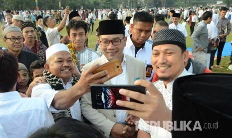 Gubernur Jawa Barat Ridwan Kamil berfoto bersama dengan masyarakat usai shalat Idul Adha 1440 H, di Lapangan Gasibu, Kota Bandung, Ahad (11/8).