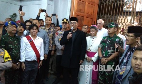 Gubernur Jabar Ridwan Kamil (berpeci) didampingi Kapolda Jabar Irjen Agung Budi Maryoto dan Wakil Wali Kota Bandung Yana Mulyana, menyampakan sambutaan saat meninjau pelaksanaan misa malam Natal 2018, di Gereja Katedral Santo Petrus Bandung, Senin (24/12). 