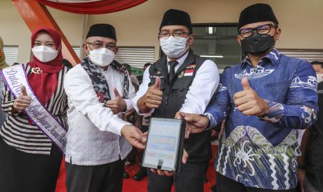 Gubernur Jawa Barat Ridwan Kamil (kedua kanan) bersama Wali Kota Depok Mohammad Idris (kedua kiri) dan Wali Kota Bogor Bima Arya (kanan) menunjukkan aplikasi Sapawarga saat meresmikan Pasar Rakyat Jabar Juara Sawangan di Sawangan, Depok, Jawa Barat, Jumat (8/4/2022). Acara tersebut dalam rangka peresmian Pasar Rakyat Jabar Juara Sawangan dan Launching Pemesanan Minyak Goreng Curah Bersubsidi melalui aplikasi Sapawarga yang bertujuan untuk membantu warga