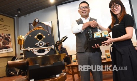 Gubernur Jawa Barat Ridwan Kamil (kiri) bersalaman dengan Deputy Director Corporate Communications CRP Group Sarita Sutedja usai meresmikan Paberik Kopi Upnormal di Paberik Kopi Upnormal Coffee Roasters, Jalan Cihampelas, Kota Bandung, Sabtu (22/6).