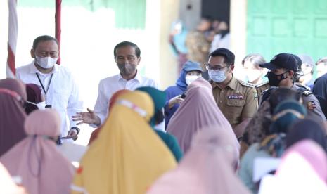 Gubernur Jawa Barat Ridwan Kamil mendampingi Presiden RI Joko Widodo membagikan Bantuan Langsung Tunai kompensasi minyak goreng dan bantuan modal usaha kepada para pedagang di Pasar Tradisional Kanoman, Lemahwungkuk, Kota Cirebon, Rabu (13/4/2022). 