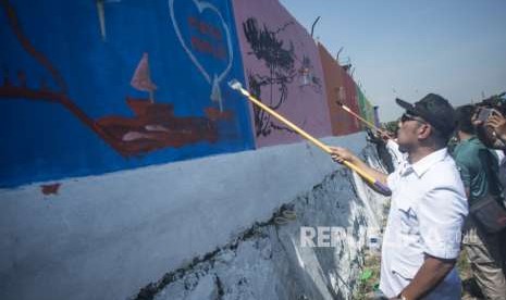 Gubernur Jawa Barat Ridwan Kamil menggambar mural Persib-Persija Damai di bantaran Sungai Citarum, Bojongsoang, Kabupaten Bandung, Jawa Barat, Rabu (26/9).