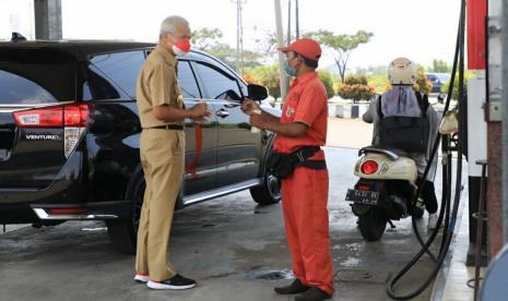 Gubernur Jawa Tengaah, Ganjar Pranowo berdialog dengan seorang operator SPBU Pertamina di Kaliwungu, Kabupaten Kendal, Jawa Tengah, Senin (11/4). Gubernur Ganjar Pranowo mendapati jalan rusak di jalur alternatif mudik.