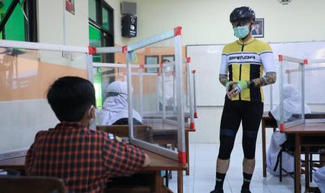 Gubernur Jawa Tengah, Ganjar Pranowo berdialog dengan siswa saat meninjau pelaksanaan PTM di SMPN 5 Semarang, Rabu (29/9). Gubernur mengapresiasi evaluasi dan perbaikan yang telah dilakukan di sekolah ini guna menyusun SOP PTM yang benar.