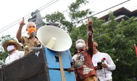 Gubernur Jawa Tengah Ganjar Pranowo bersama sejumlah wakil rakyat Provinsi Jawa Tengah, menemui massa buruh yang menggelar aksi menyuarakan penolakan terhadap UU Cipta Kerja di depan gedung DPRD Provinsi jawa Tengah, Senin (12/10). 