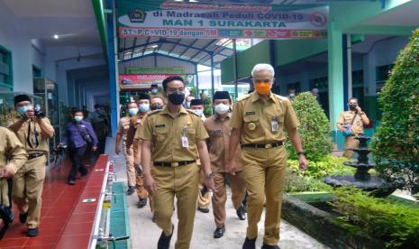 Gubernur Jawa Tengah Ganjar Pranowo, didampingi Wali Kota Solo Gibran Rakabuming Raka, saat meninjau simulasi pembejalaran tatap muka (PTM) di MAN 1 Solo, Senin (29/3)