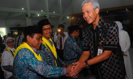 Gubernur Jawa Tengah Ganjar Pranowo (kanan) menyalami para jamaah calon haji saat pelepasan keberangkatan kloter pertama calon haji Jawa Tengah di Asrama Haji Donohudan, Boyolali, Jawa Tengah, Selasa (9/8). 