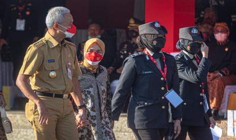 Gubernur Jawa Tengah Ganjar Pranowo (kiri) bersama istrinya, Siti Atikoh (kedua kiri) berjalan saat menghadiri Upacara HUT Ke-76 Bhayangkara yang dipusatkan di Kampus Akademi Kepolisian, Semarang, Jawa Tengah, Selasa (5/7/2022). Upacara tersebut melibatkan 1.996 perseonel yang terdiri atas unsur Polri, TNI, dan eksponen masyarakat dengan mengusung tema Polri yang Presisi Mendukung Pemulihan Ekonomi dan Reformasi Struktural untuk Mewujudkan Indonesia Tangguh, Indonesia Tumbuh. 