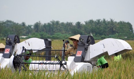 Gubernur Jawa Tengah Ganjar Pranowo, mengemudikan mesin panen pada pada acara panen raya di Desa Mrenek, Maos, Cilacap, Jateng, Senin (29/2). (Antara/Idhad Zakaria)