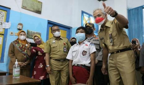 Gubernur Jawa Tengah, Ganjar Pranowo saat berdialog dengan peserta didik peserta vaksinasi anak usia 6 – 11 tahun di SDN Podosugih 03, Kecamatan Pekalongan Barat, Kota Pekalongan, Senin (20/12).