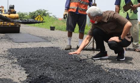 Gubernur Jawa Tengah, Ganjar Pranowo saat menemui para pekerja yang melaksanakan penambalan jalan di kawasan exit tol Brebes, Selasa (25/1). Gubernur minta pengelola jalan tol di Jawa Tengah cepat melakukan perbaikan apabila ada ruas tol yang berlubang.