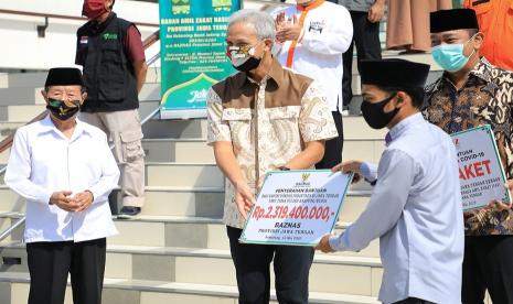 Gubernur Jawa Tengah, Ganjar Pranowo saat menyerahkan secara simbolis bantuan Baznas Provinsi Jawa Tengah, kepada para santri yang masih bertahan dan tidak mudik di berbagai ponpes di Jawa Tengah, di masjid Baiturrahman, Semarang, Rabu (13/5). 