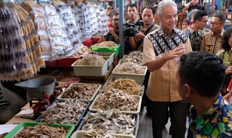 Gubernur Jawa Tengah Ganjar Pranowo (tengah) menyapa pedagang saat sidak harga dan ketersediaan Sembako jelang Lebaran di pasar Rejowinangun Kota Magelang, Jawa Tengah Kamis (23/5/2019).