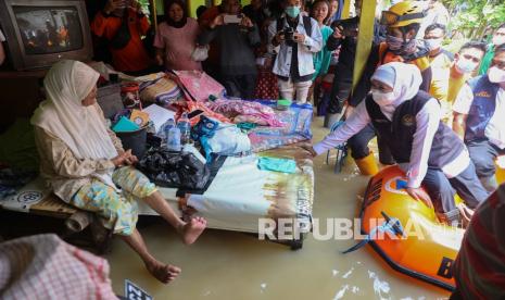 Gubernur Jawa Timur Khofifah Indar Parawansa (kanan) memberi bantuan kepada warga terdampak banjir di Desa Sumedangan, Kecamatan Pademawu, Pamekasan, Jawa Timur, Rabu (2/3/2022). Tiga dari lima kecamatan yaitu Palengaan, Proppo dan sebagian Kecamatan Galis yang sebelumnya tergenang banjir akibat luapan Sungai Kalikloang dan Kalisemajid kini mulai surut, sedangkan Kecamatan Pamekasan dan Pademawu masih tergenang. 