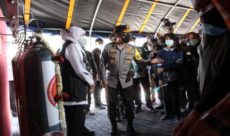 Gubernur Jawa Timur Khofifah Indar Parawansa (kiri) dan Kapolda Jawa Timur Irjen Pol Nico Afinta (kedua kiri) meninjau stasiun pengisian tabung oksigen medis secara gratis di halaman Unit Pelaksana Teknis Pengelolaan Pendapatan Daerah Sidoarjo, Jawa Timur, Senin (19/7/2021). Kurangnya sosialisasi tentang stasiun pengisian oksigen medis gratis tersebut membuat lokasi tersebut masih sepi dari warga yang mengisi ulang tabungnya.