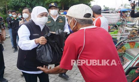 Gubernur Jawa Timur Khofifah Indar Parawansa (kiri) didampingi Bupati Tulungagung Maryoto Birowo (tengah) menyerahkan bantuan sembako kepada pengayuh becak di sela kegiatannya meninjau pelaksanaan vaksinasi COVID-19 yang digelar Ikatan Sarjana Nahdlatu Ulama (ISNU) di Universitas Islam Negeri Sayyid Ali Rahmatullah Tulungagung (UIN SATU), Tulungagung, Jawa Timur, Sabtu (18/9/2021). Gubernur berharap keterlibatan kampus/perguruan tinggi serta multipihak lain dalam penyelenggaraan vaksinasi OVID-19 akan mempercepat terbentuknya kekebalan komunal atau herd immunity.