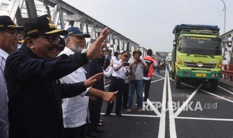 Gubernur Jawa Timur Soekarwo (kiri) menyapa pengendara yang melintasi Jembatan Widang ketika meninjau jembatan tersebut, Tuban, Jawa Timur, Rabu (6/6).