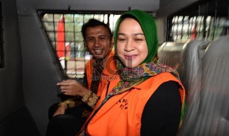 Gubernur Non Aktif Sumatera Utara Gatot Pujo Nugroho (kiri) bersama Istri Evy SUsanti (kanan) berjalan menuju mobil tahanan setelah menjalani pemeriksaan di Gedung KPK, Jakarta, Selasa (25/8). 