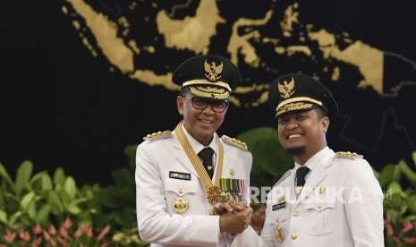 Gubernur Nurdin Abdullah (kiri) bersama Wakil Gubernur Sudirman Sulaiman (kanan) melakukan salam komando usai pelantikan di Istana Negara, Jakarta, Rabu (5/9).