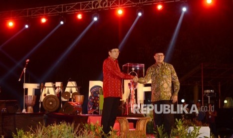  Gubernur Nusa Tenggara Barat (NTB) M. Zainul Majdi (kiri) menerima piala MTQ Nasional dari Menteri Agama Lukman Hakim Saifuddin (kanan) saat malam Ta’aruf yang diadakan di Pendopo Kantor Gubernur NTB, Jumat (29/7) malam.(Republika/Raisan Al Farisi)