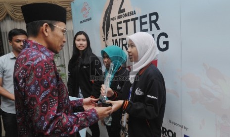 Gubernur Nusa Tenggara Barat TGH Muhammad Zainul Majdi menyerahkan piala kepada pemenang Letter Writing Competition kerjasama PT Pos dengan Republika di Aula kantor Gubernur NTB, Ahad (9/8) malam.Republika/Edwin Dwi Putranto